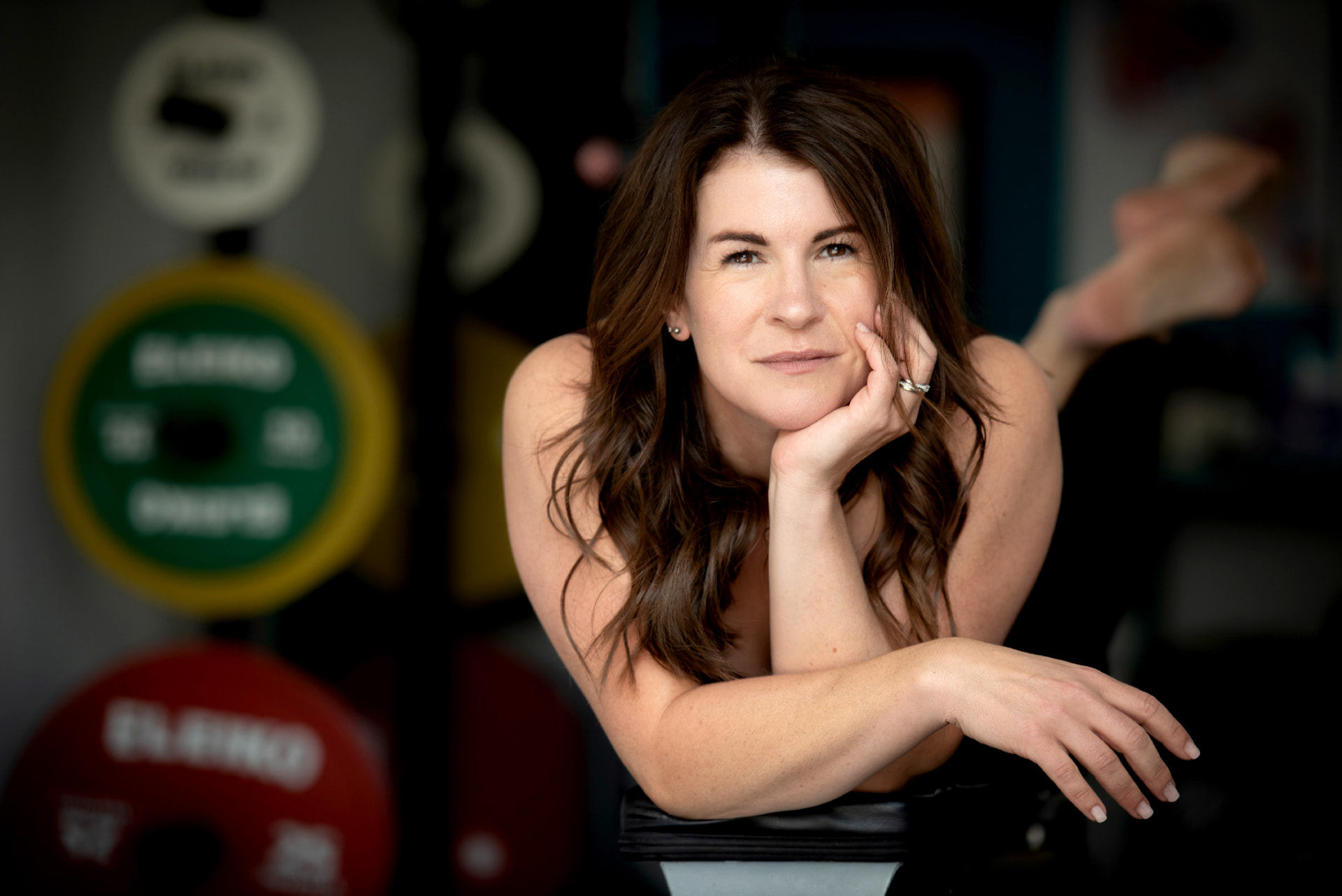 Samantha Charlwood in the gym, resting on a barbell between sets